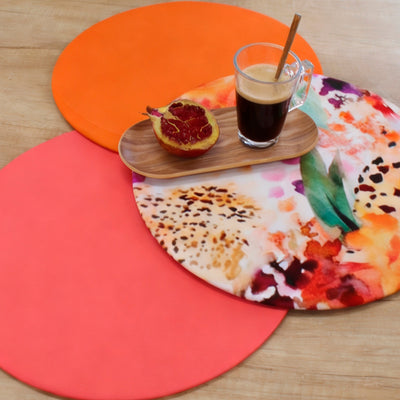 Bajoplato Funda Animal Print junto a mantelitos lisos naranja y coral, con granada y café